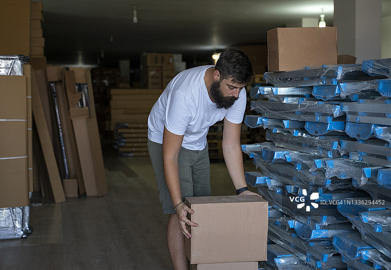 仓库工人在仓库中工作，堆叠箱子准备发货图片素材