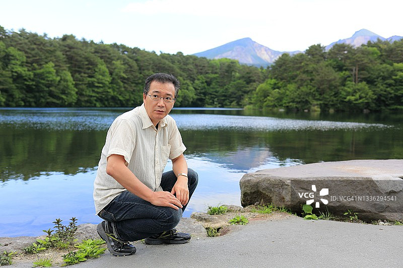 日本男子肖像，背景是磐梯山和五色沼湖图片素材