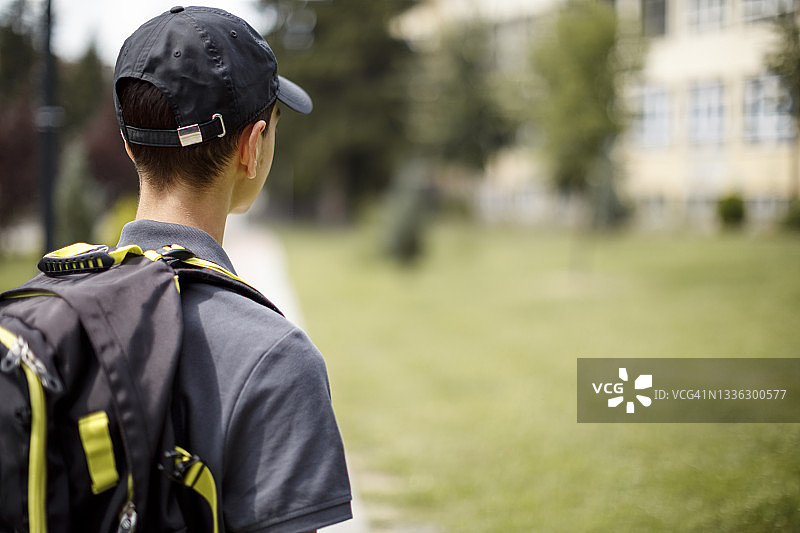 在学校前的青少年男孩的背影图片素材