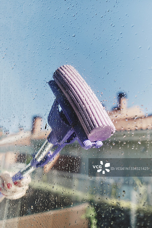 用橡胶刮刀清洁满是肥皂的窗户图片素材