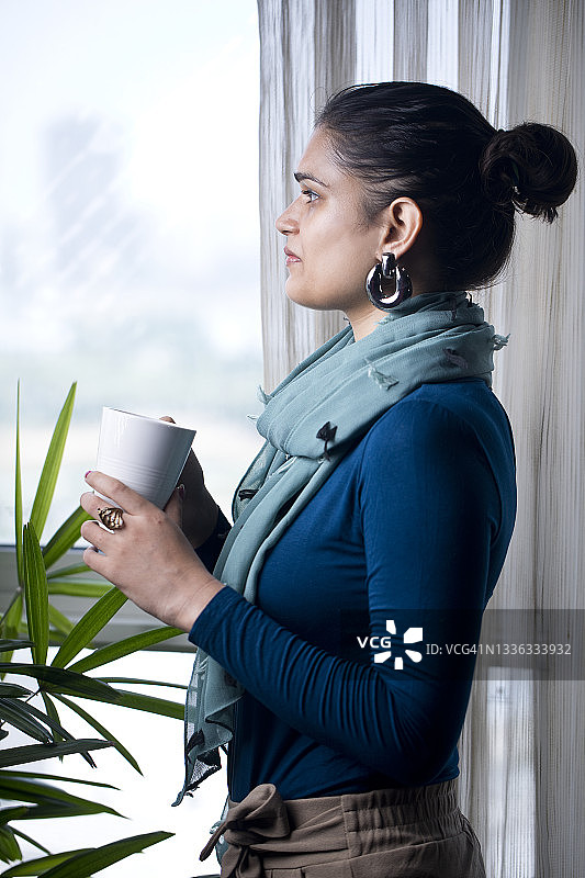 喝咖啡并向窗外看的女人图片素材