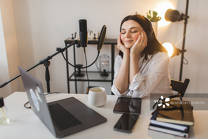 女人在工作桌前对着麦克风用手势激情地演讲图片素材