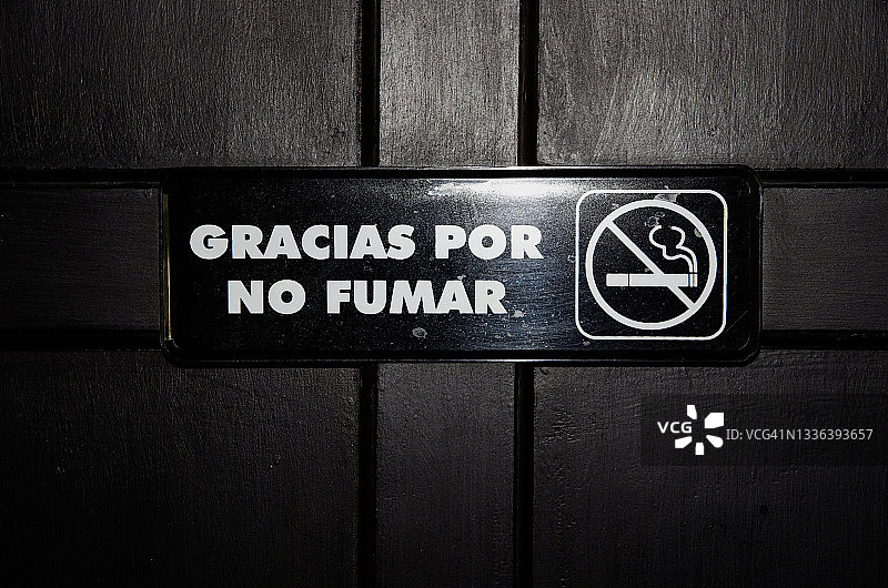 酒店门后西班牙语“禁止吸烟”标志，写着“感谢您的不吸烟”图片素材