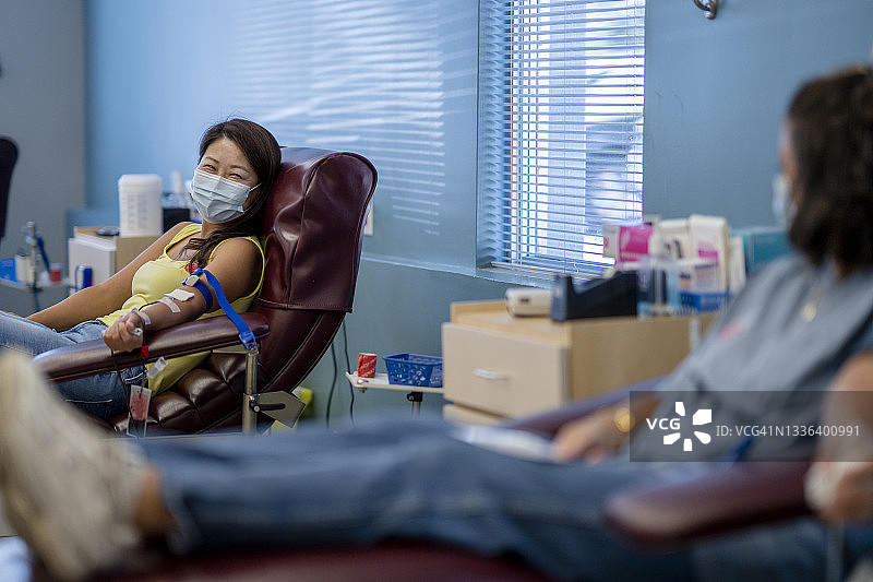 戴口罩的成年女性在献血活动中图片素材