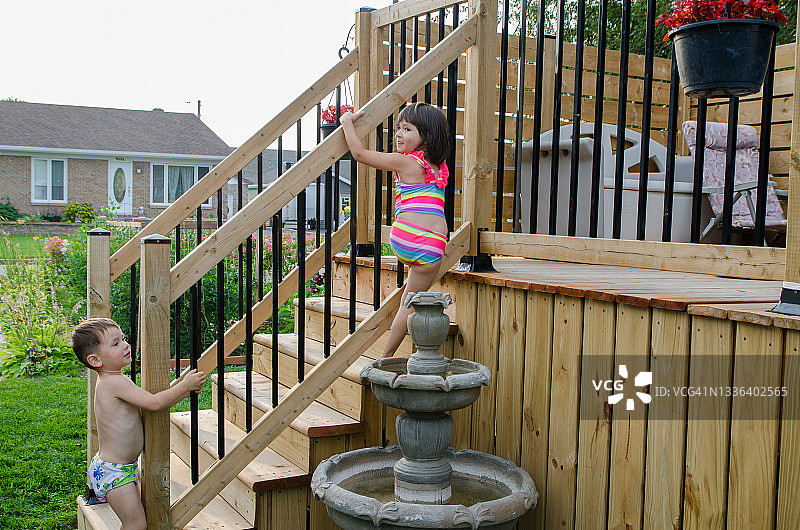 两个孩子绕过泳池安全门图片素材