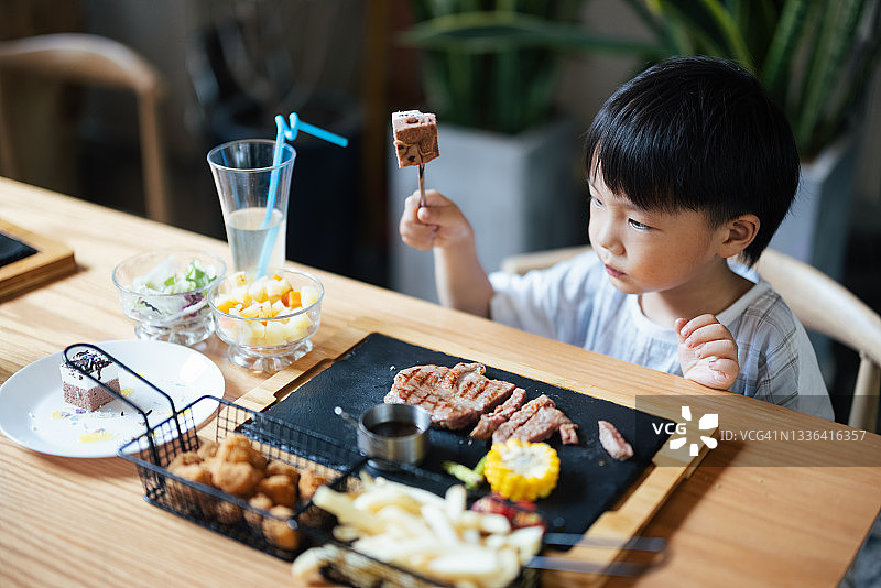 小男孩在餐厅吃饭图片素材