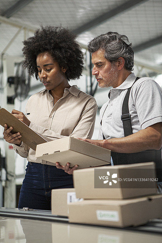 女快递员在配送中心准备包裹图片素材