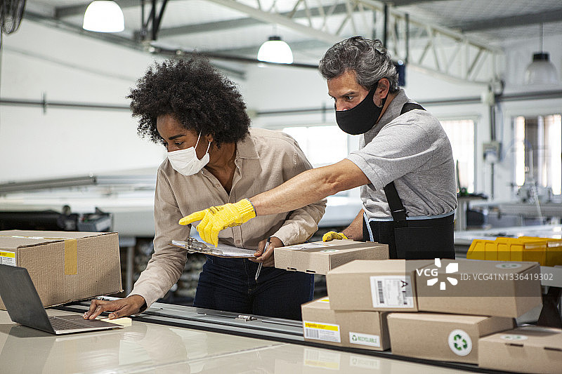 男女配送仓库工人准备纸板箱发货的侧视图图片素材