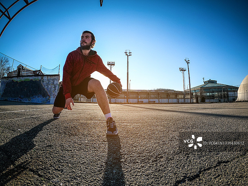年轻男人独自在篮球场训练图片素材