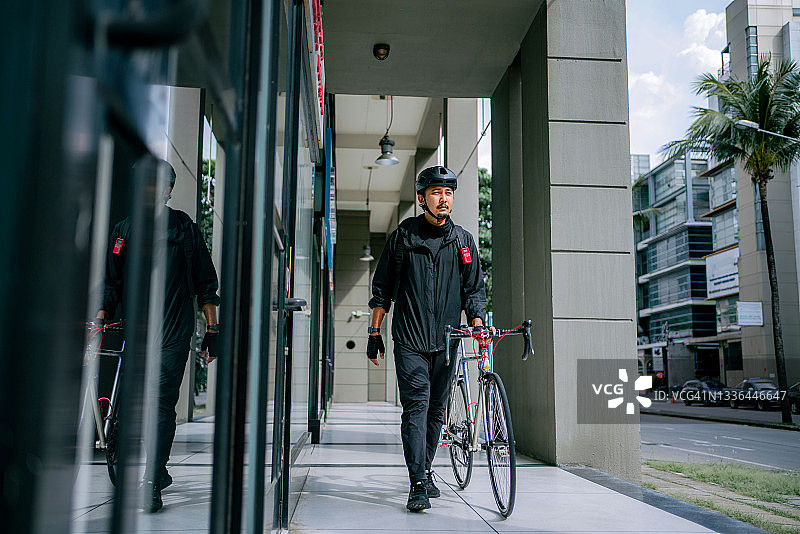 在城市中奔波的亚洲外卖员图片素材