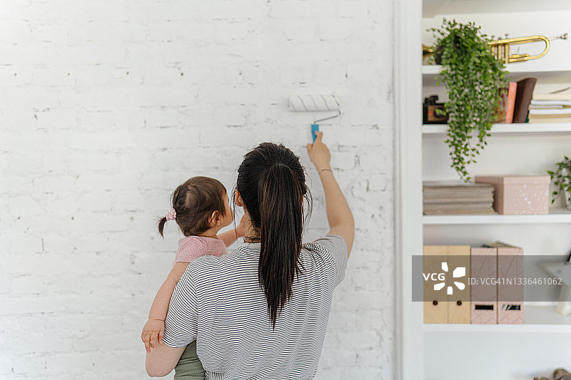 妈妈和宝宝在客厅里刷墙图片素材