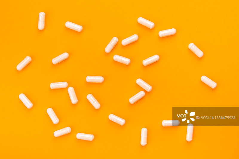 橙色背景上的米色药丸图片素材