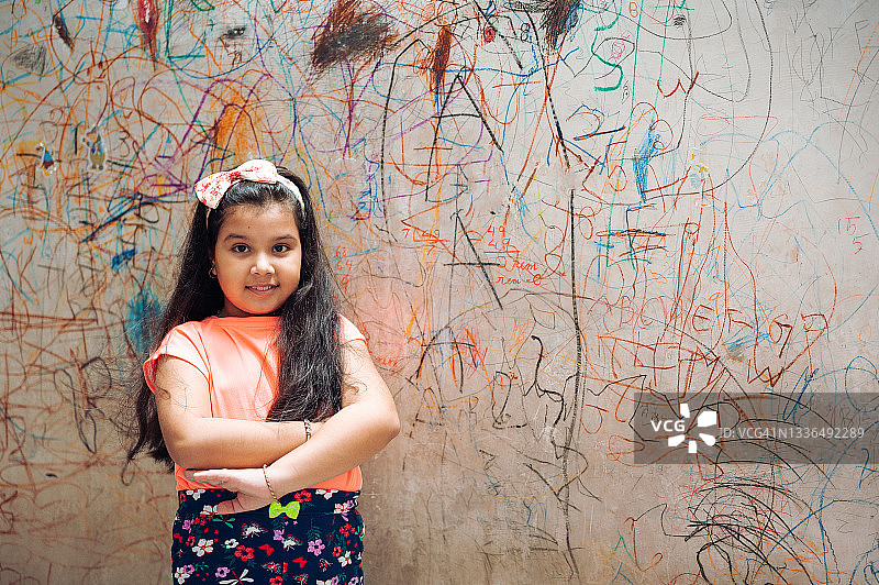 可爱小女孩在家用马克笔墙上作画图片素材