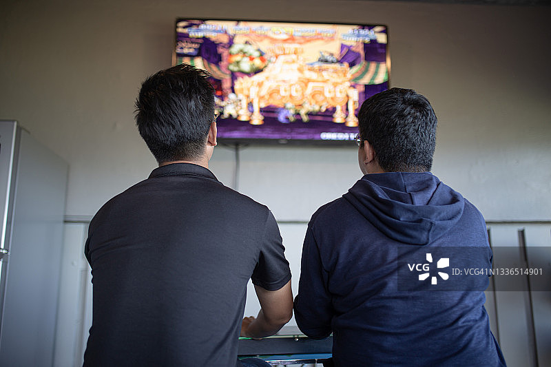 周末聚会中玩复古游戏的亚洲男人图片素材