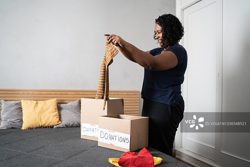 女人在家整理要捐赠的盒装衣物图片素材