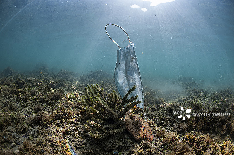 漂浮在海面上的废弃医用口罩，新冠病毒概念图片素材