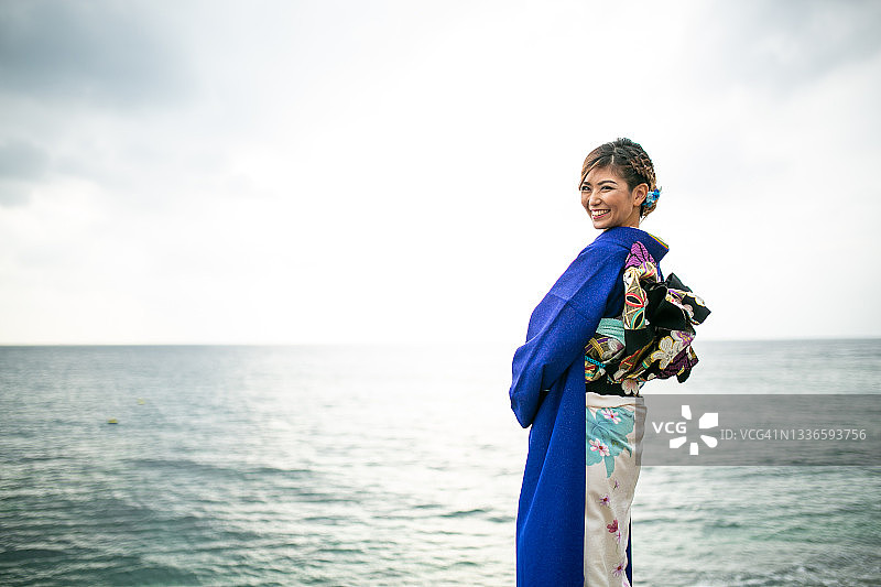 身穿和服的年轻日本女子，背景为海洋图片素材