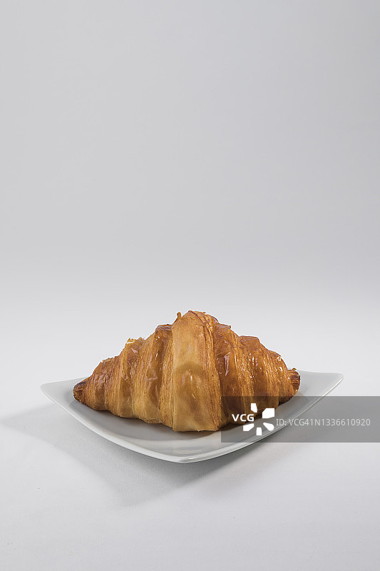 白色盘子里的普通羊角面包图片素材