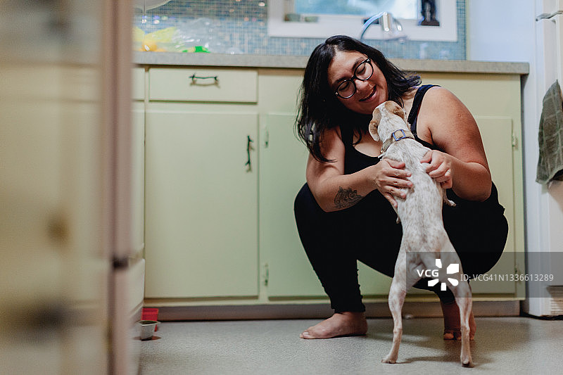 年轻女子在家拥抱她的狗图片素材
