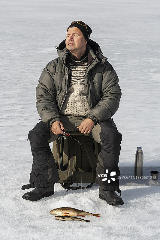 男人在晴朗的一天冰钓图片素材