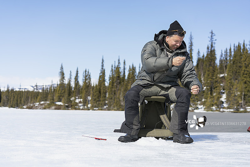 男人在晴朗的一天冰钓图片素材