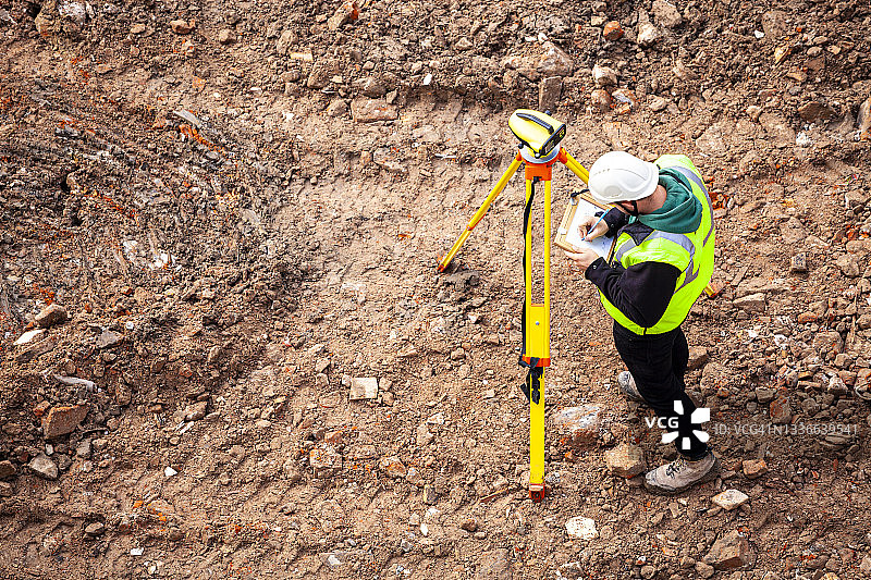 一位测量员在建筑工地上使用光学水平仪图片素材