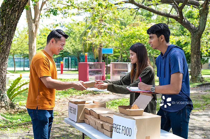 多民族志愿者在户外食物银行慈善活动中为有需要的家庭和当地社区提供免费食物图片素材