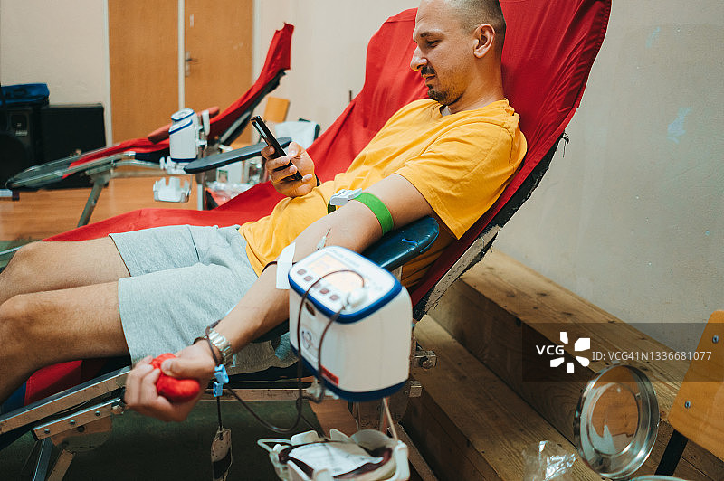 献血者正在使用手机图片素材
