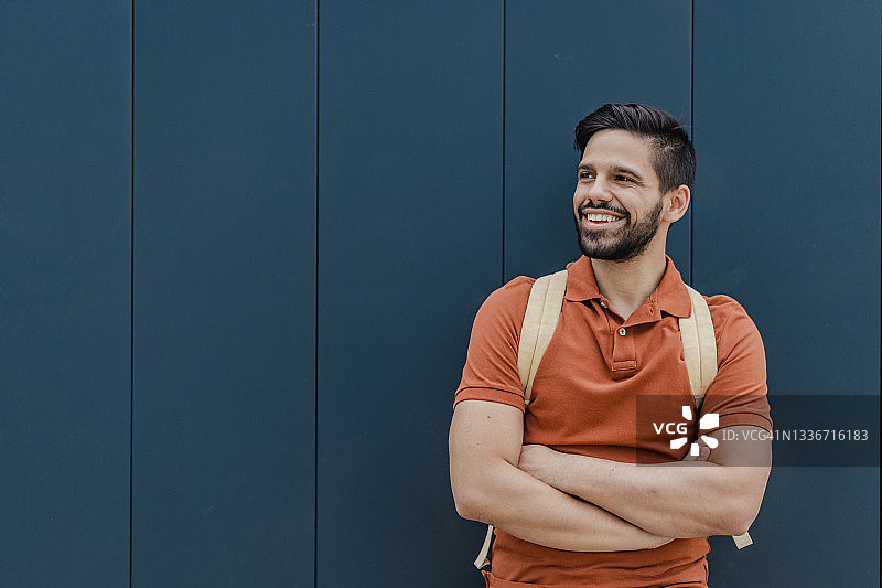 黑墙前微笑的年轻男人图片素材
