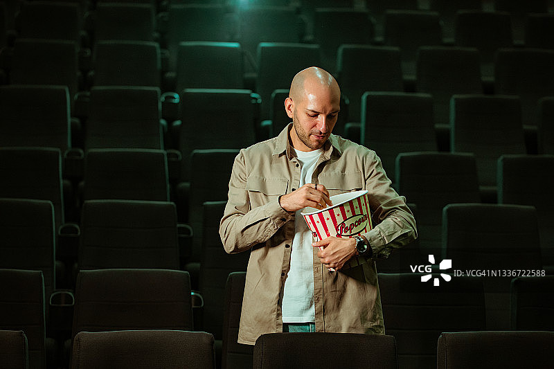 男人在电影院吃爆米花的肖像图片素材