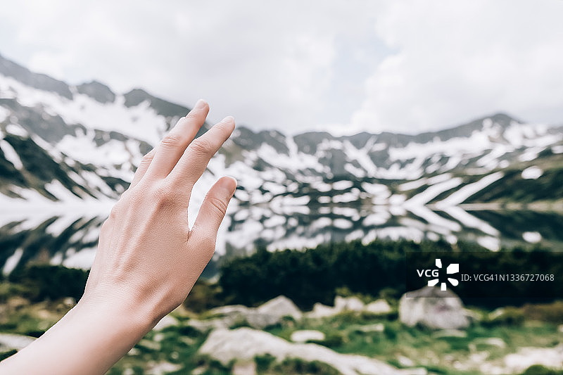 女人的手与湖泊和山脉的景色图片素材