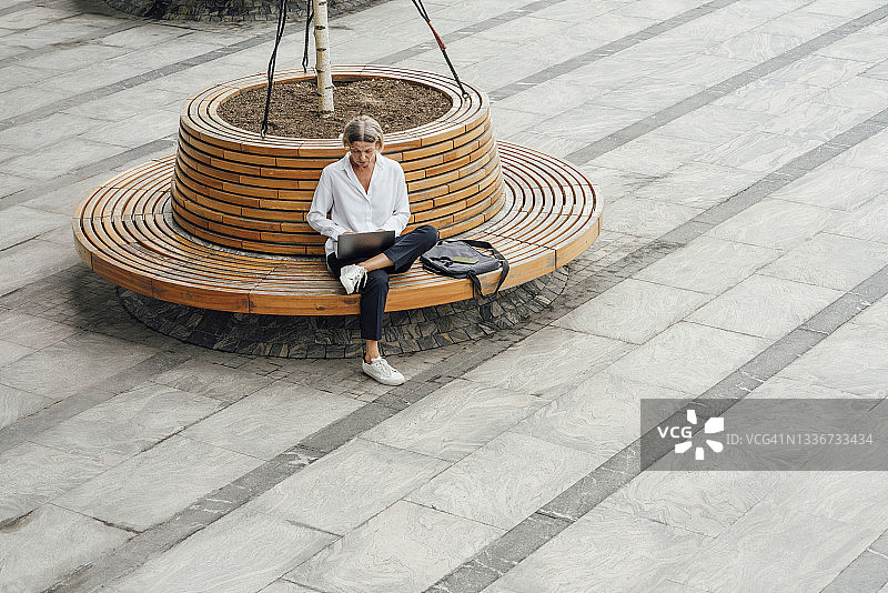 在座位上使用笔记本电脑的中年女职员图片素材