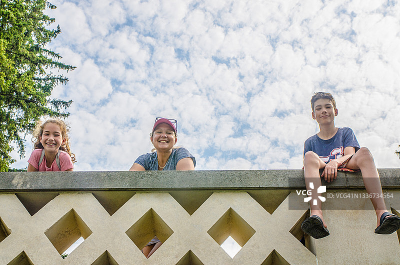 站在水泥墙后的女人和青少年男女图片素材