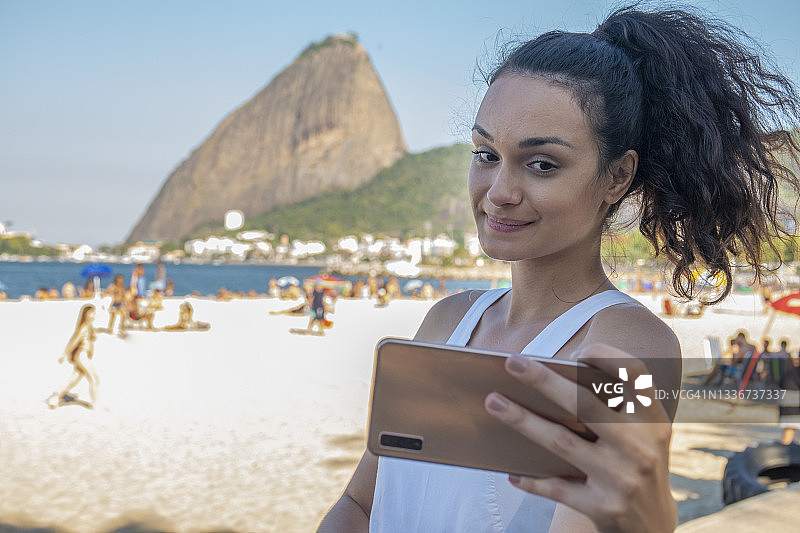 年轻女人在糖面包山下自拍图片素材