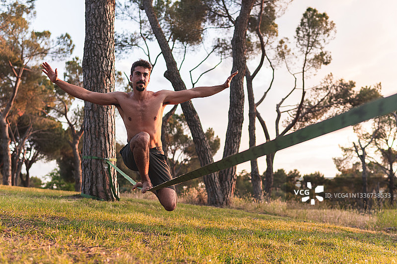 男子在日落时分伸出双臂玩走扁带图片素材