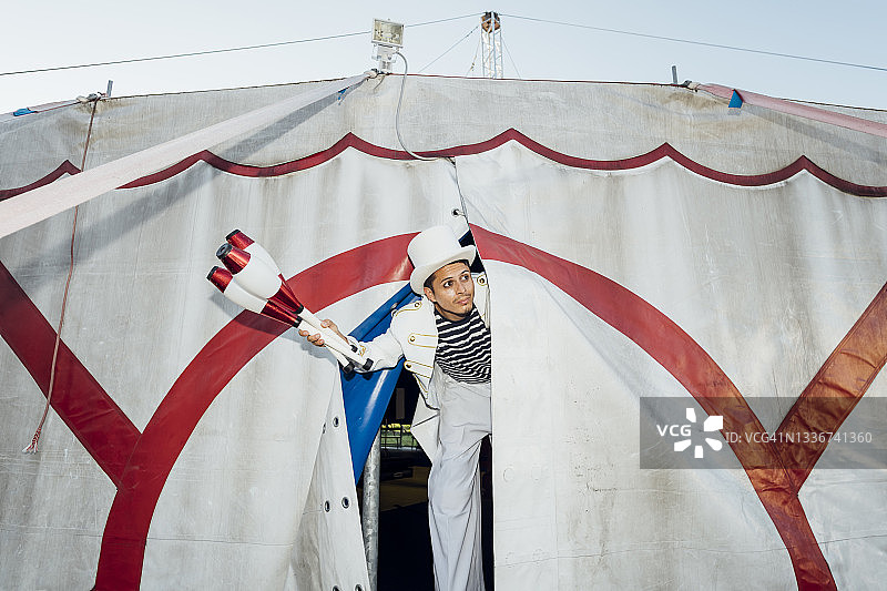 男性杂耍演员在马戏团帐篷里踩着高跷耍弄杂耍棒图片素材