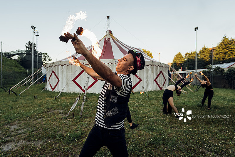 笑容满面的男火舞演员在马戏团练习图片素材