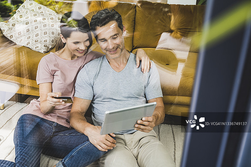 男人和女人在家中使用平板电脑进行在线支付图片素材