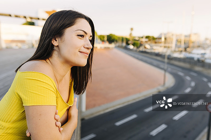 年轻女人倚靠栏杆看向远方图片素材