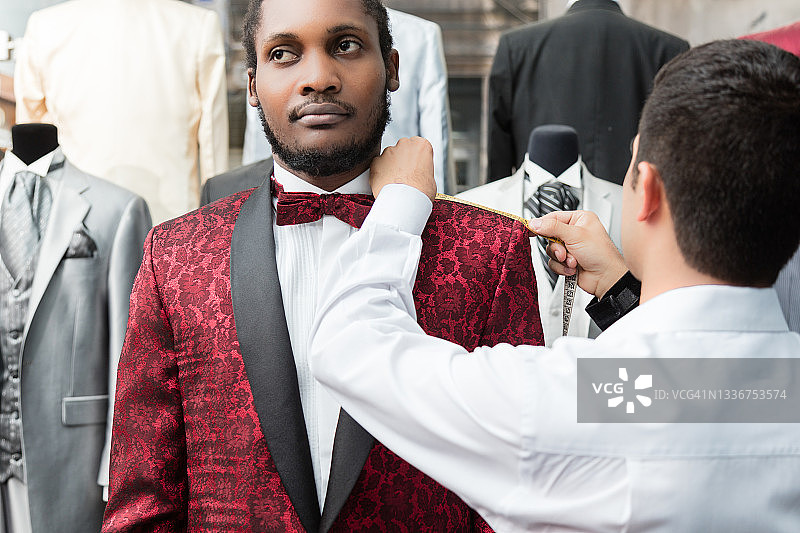 裁缝在店铺里为非裔美国男士量身定制燕尾服图片素材