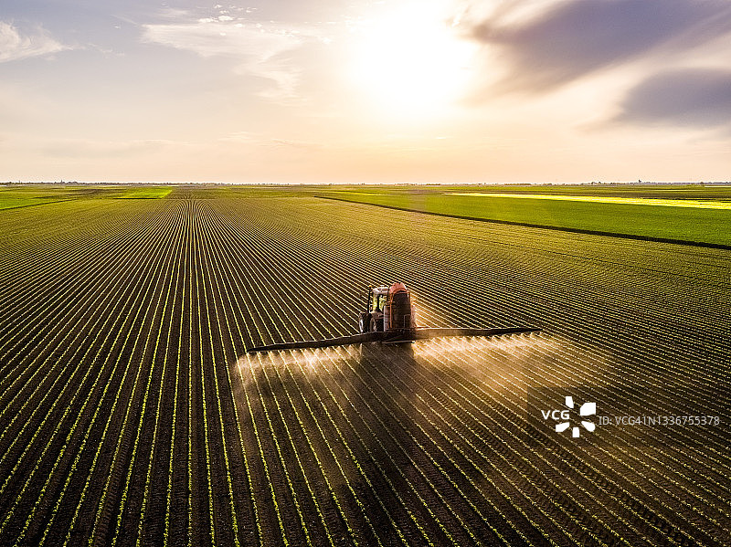 日落时拖拉机喷洒大豆作物的航拍视角图片素材