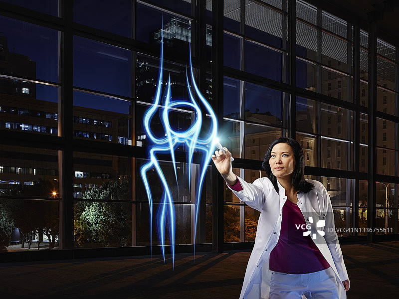 在医院实验室检查膝关节的年长女骨科医生图片素材