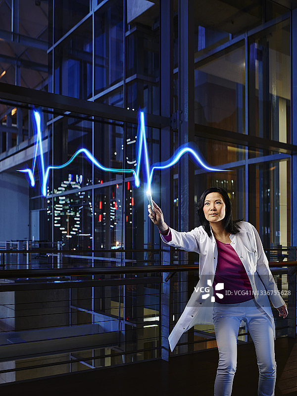 中年女心脏病专家在医院检查脉搏图片素材