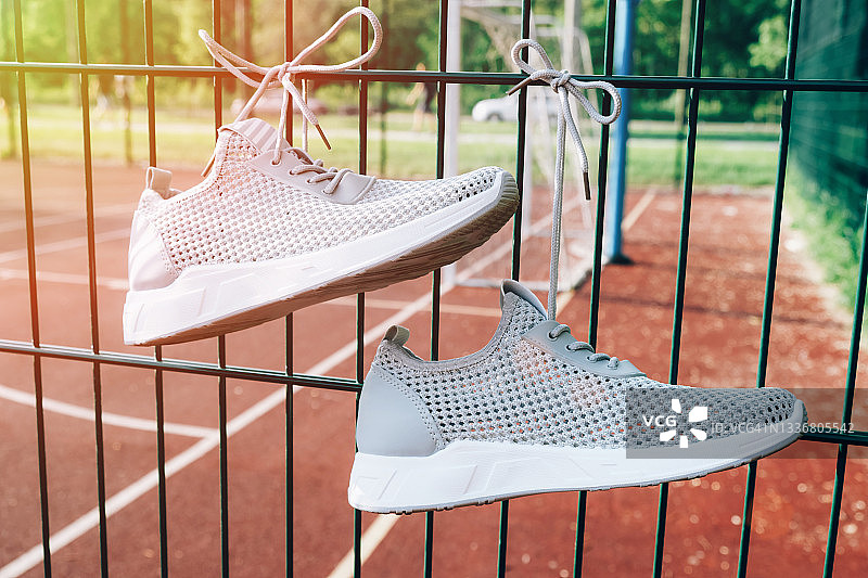 阳光下的运动场上的灰色女士运动鞋图片素材