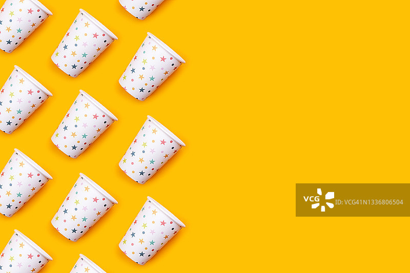 黄色桌面上带彩色星星的纸杯图片素材