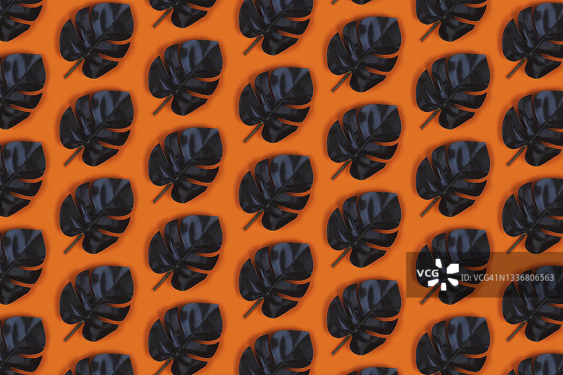 橙色背景上的绿叶图案图片素材