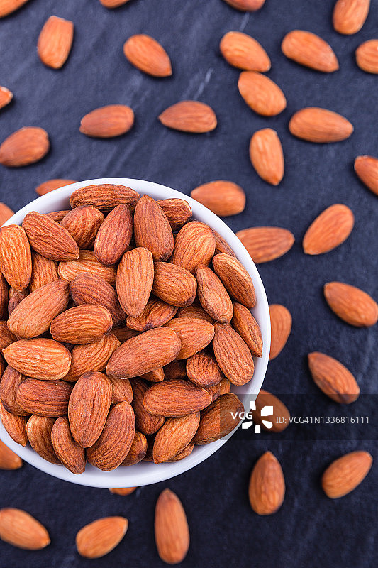 石桌上的木碗杏仁图片素材