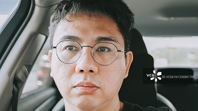 坐在车里表情严肃看向远方的中年男人图片素材