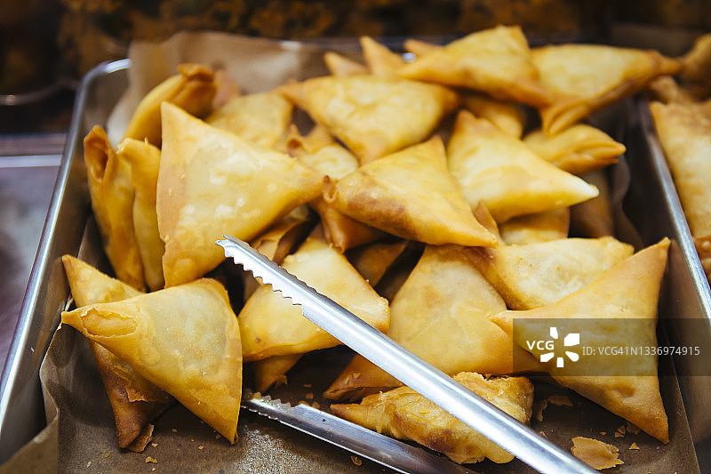 商店橱窗里的萨摩萨三角饺和夹子拼盘图片素材