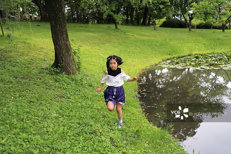 在公园草地上奔跑的小女孩图片素材